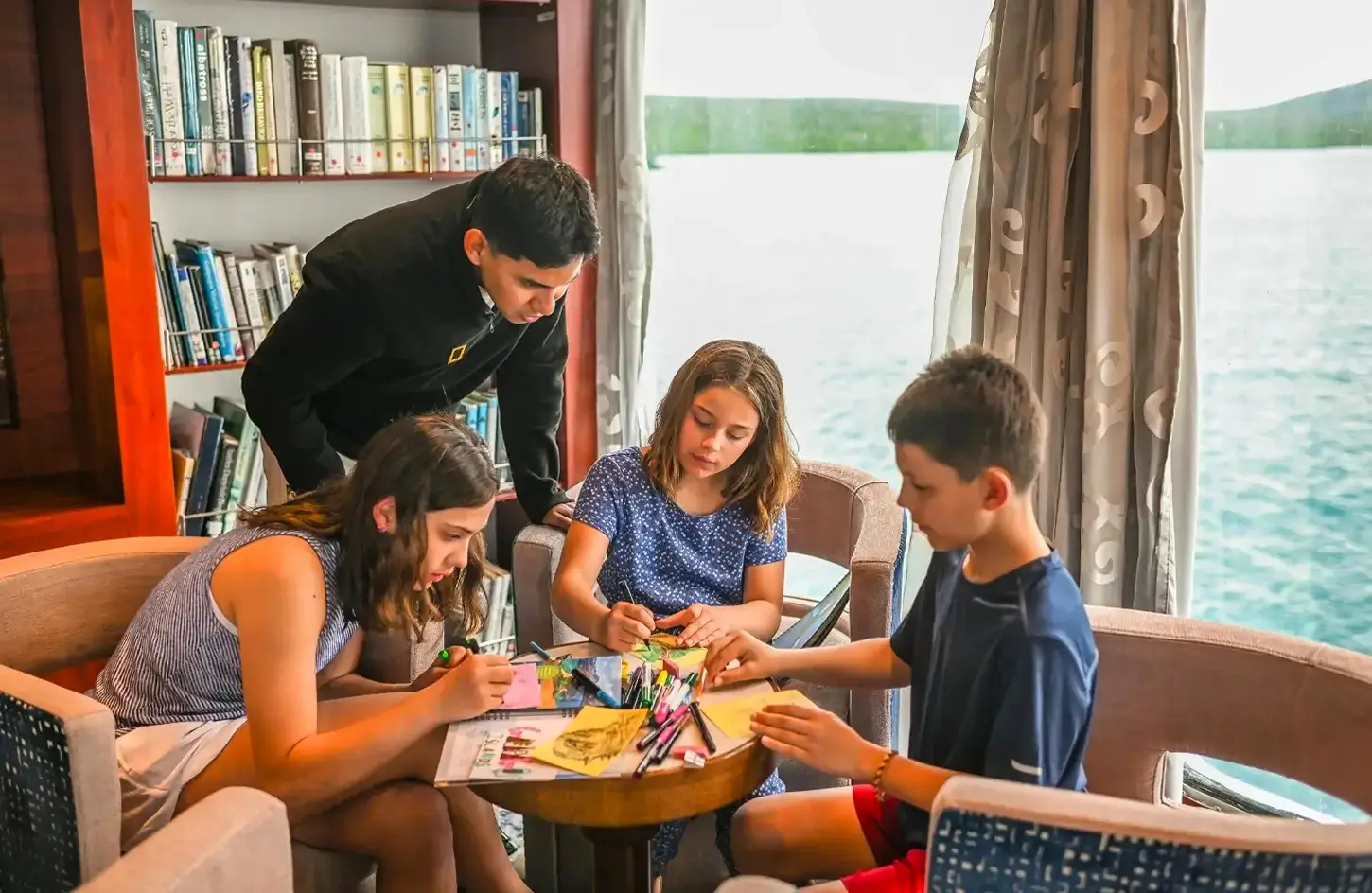 Kids drawing with a guide in a cruise ship lounge